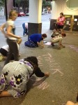 Women all working together to chalk supportive messages for women in need.
