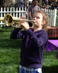 A young woman gets her first try at playing a trumpet at the Brubeck Jazz Festival