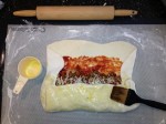 Coating pizza dough with olive oil.