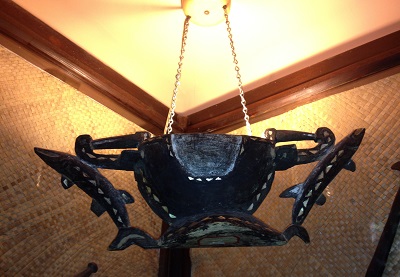 Polynesian serving bowl ceiling lamp with chain suspension.