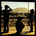 Young children look out the observation deck of the De Young Museum toward Sutro Tower.