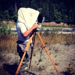 Photographer using a 5x7 glass plate camera takes pictures at the dry lake bed of Lake Elwha.