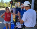 Gia McNutt chats with local Auburn resident about her utility box micro mural project.