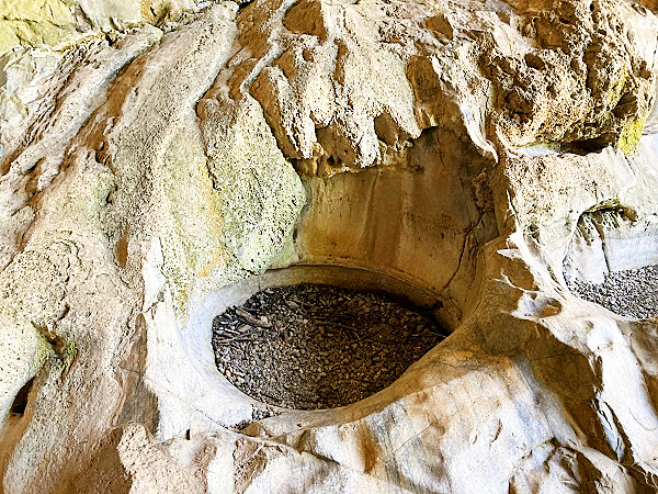 What looks like a round stone pot, perhaps shaped by Native Americans, for cooking inside Natural Bridges tunnel.