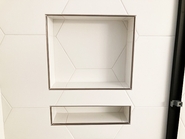 Soap and shampoo recessed shower cubby with matching tile.