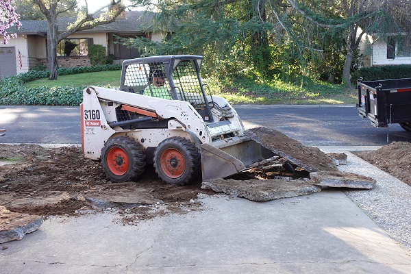 Small front end loader used to lift and break up the old concrete driveway.