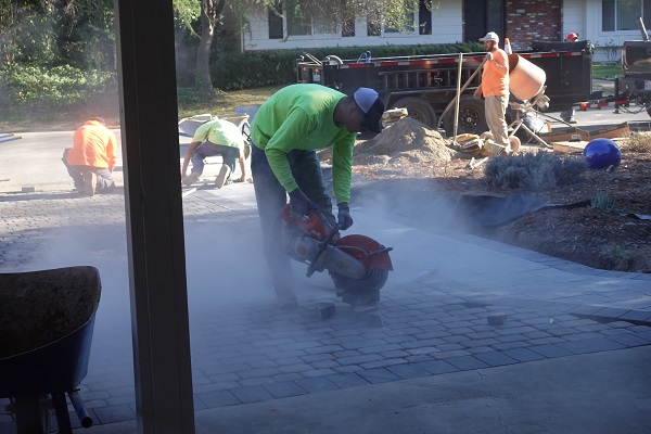 Concrete saw used to cut pavers for different angles created by walkway and street.