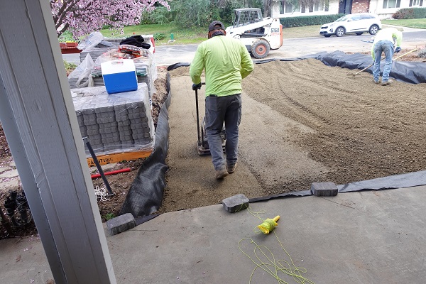 Road base gravel is dumped in to the excavated driveway footprint, approximately 8 inches in depth, and compacted.
