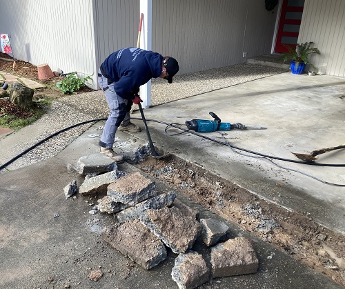 Cutting out concrete driveway to install water line to the house.